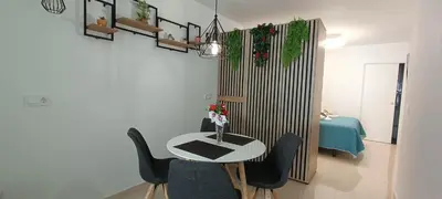 a table with black chairs and a vase with flowers at Precioso Loft Sorolla en Playa Malvarrosa/Patacona in Valencia