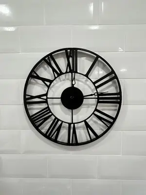 a black clock hanging on a white wall at Patraix nice suite in Valencia