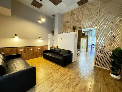 a living room with a black leather couch and wooden floors at Lliri 7 in Valencia
