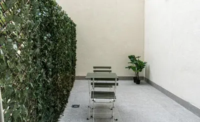 two chairs and a table in front of a wall at Osito Hub - Duque de Gaeta in Valencia