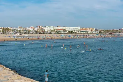 a group of people in the water at a beach at MalvaLindaBeach Loft Benlliure Malvarrosa/Patacona in Valencia