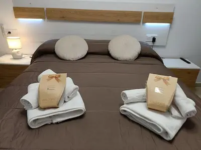 a bed with white towels and pillows on it at MalvaLindaBeach Loft Benlliure Malvarrosa/Patacona in Valencia