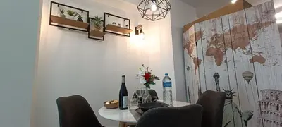 a dining room table with chairs and wine bottles on it at MalvaLindaBeach Loft Benlliure Malvarrosa/Patacona in Valencia