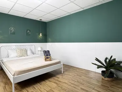 a bedroom with a white bed and a green wall at Cooperativa 8 in Valencia