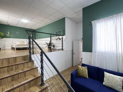 a living room with a blue couch and a staircase at Cooperativa 8 in Valencia