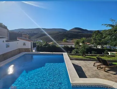 a swimming pool in front of a house at Chalet con piscina, barbacoa y jacuzzi en Valencia in Turís