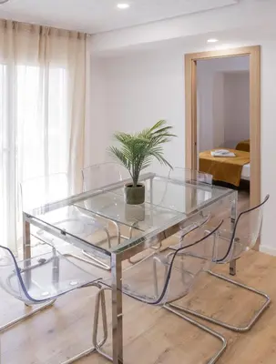 a glass table with chairs and a potted plant at Furio Silence in Valencia