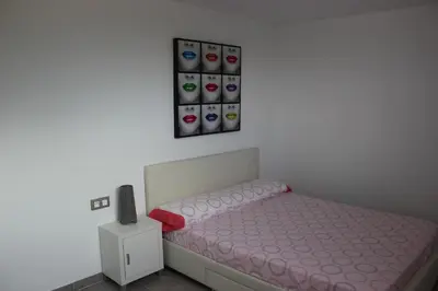 a bedroom with a bed with pink sheets and a small night stand at Sierra de Chiva Villa in Chiva