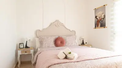 a bedroom with a pink bed with two white towels at Tú & Yo Moncofa in Moncófar