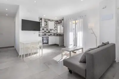 a white living room with a couch and a table at Placid Puerto in Puerto de Sagunto