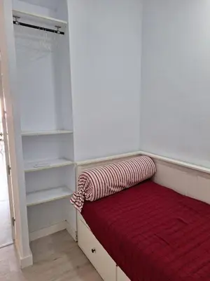 a bed with a red blanket on it in a room at Cullera Playa in Cullera