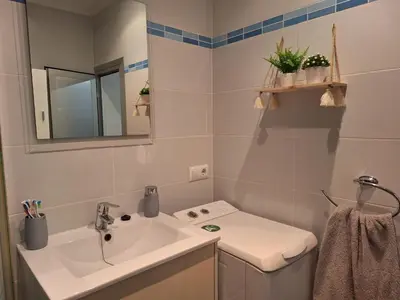 a white bathroom with a sink and a mirror at Cullera Playa in Cullera