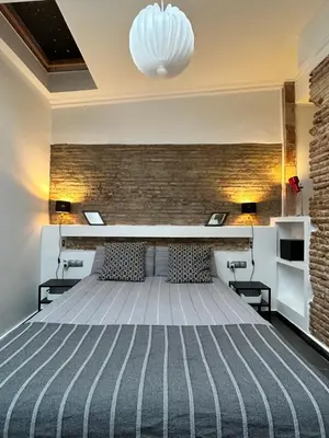 a bedroom with a bed and a brick wall at Apartamento chic en Ciutat Vella in Valencia