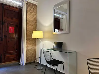 a room with a desk with a laptop and a lamp at Apartamento chic en Ciutat Vella in Valencia