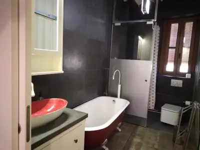 a bathroom with a white tub and a red sink at Valencia Centro Suite in Valencia