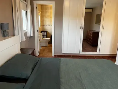 a bedroom with a bed and a bathroom with a mirror at Casa el Girasol, rustig gelegen kindvriendelijke villa 10 p in Montroy