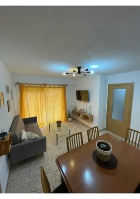 a living room with a table and a couch at Cullera Playa in Cullera
