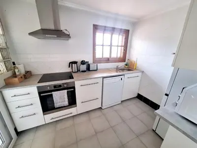 a white kitchen with a stove and a sink at Cap Blanc Apartment with Sea View and Beach in Cullera