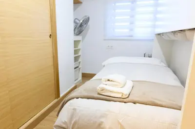 two beds in a room with towels on the bed at Apartamento pobla farnals playa precioso in Las Canteras