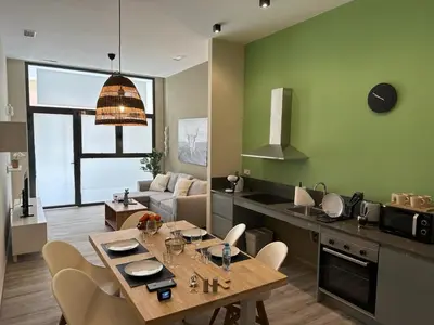 a kitchen and living room with a table and chairs at Loft para 6 pax, 15 min de Ciencias y Artes y AC in Valencia