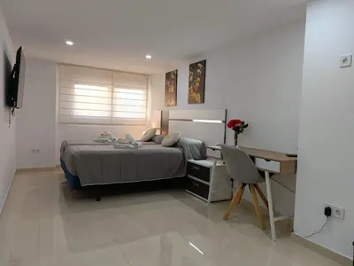 a bedroom with a bed and a desk at MalvaLindaBeach Preciosa Casa Malvarrosa-Patacona in Valencia