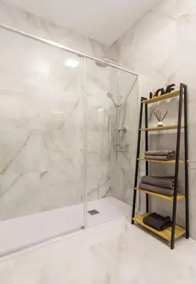 a bathroom with a shower and a shelf with towels at Apartamento Exclusivo en Valencia in Valencia