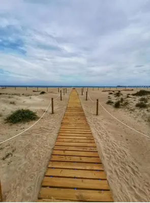 a wooden path through the sand on a beach at UIM Mediterraneo Cendoya 4 Wifi in Puerto de Sagunto