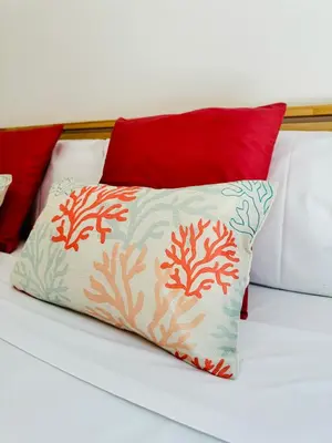 a pillow sitting on a bed with two red pillows at Stylish Apartment with Terrace on the BeachFrom in Valencia