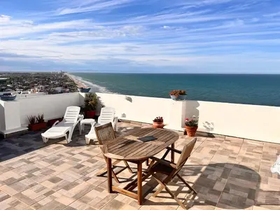 an aerial view of the ocean and a building at Ático El Faro Cullera in Faro de Cullera
