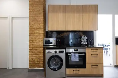 a kitchen with a washing machine and a microwave at FLORIT FLATS - The Patraix Apartments in Valencia