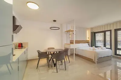 a bedroom with a bed and a table and chairs at Gulliver Suites Valencia in Valencia