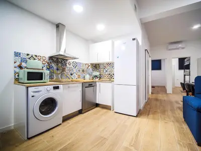 a kitchen with a washing machine and a microwave at Apartamento Disfrutones Valencia in Valencia