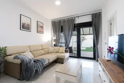 a living room with a couch and a tv at the butterfly house in Rafelbuñol
