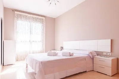 a white bedroom with a large bed and a window at Burriana Beach Retreat: Pool & Comfort in Burriana