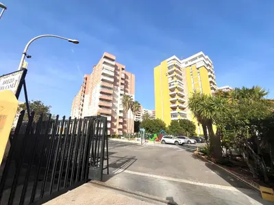 a city street with tall buildings and a black fence at Apartamento en la Playa Canet, muy cerca de Valencia in Canet de Berenguer