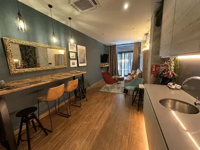 a kitchen with a bar and a living room at Magnifica vivienda a estrenar junto a Plaza España in Valencia