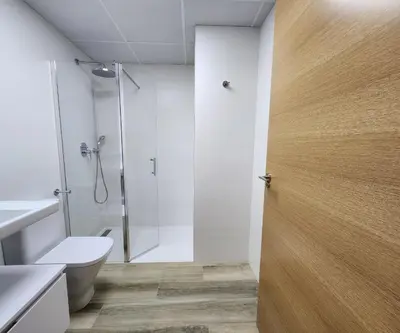 a bathroom with a shower and a toilet and a glass door at MD Pont de Fusta in Valencia