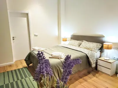 a bedroom with a bed and a vase of purple flowers at Apartamento en Valencia centro in Valencia