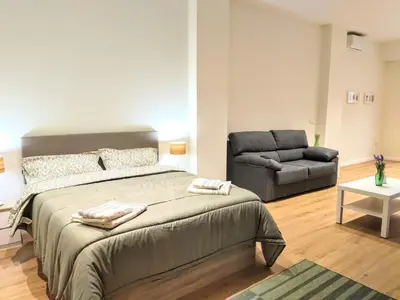 a bedroom with a large bed and a couch at Apartamento en Valencia centro in Valencia