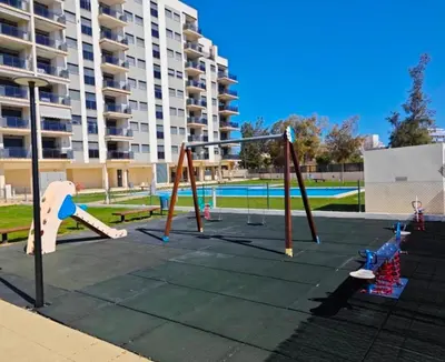 an empty playground with swings and a building at Apartamento en Playa moncófar a tan solo 300 metros in Moncófar