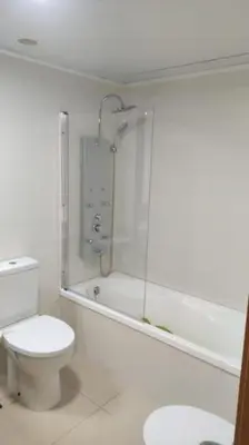 a white bathroom with a toilet and a bath tub at Apartamento en Playa moncófar a tan solo 300 metros in Moncófar