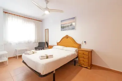 a bedroom with a large bed with a ceiling fan at Global Vacacional, Planta Baja con Piscina en Canet de Berenguer in Canet de Berenguer