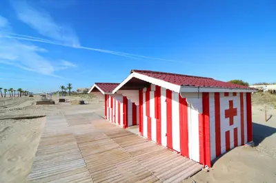 a row of beach huts on the beach at Global Vacacional, Planta Baja con Piscina en Canet de Berenguer in Canet de Berenguer
