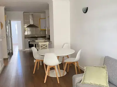 a dining room and kitchen with a table and chairs at Acogedor apartamento en primera línea de playa in Canet de Berenguer