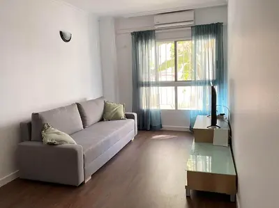 a living room with a couch and a glass table at Acogedor apartamento en primera línea de playa in Canet de Berenguer