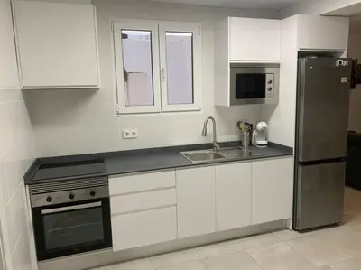 a kitchen with white cabinets and a stainless steel refrigerator at Aerofira Paterna in Paterna
