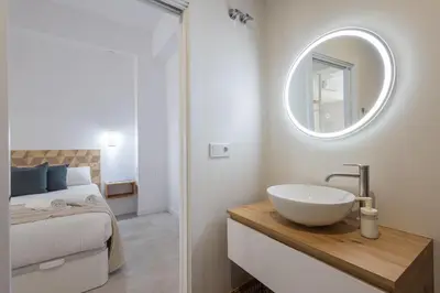 a bathroom with a sink and a bed with a mirror at FLORIT FLATS - Quiet and Cozy Studios by the Joaquin Sorolla Station in Valencia