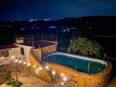 a swimming pool at night with lights around it at Villa Caliqueña, casa de campo in Torrent