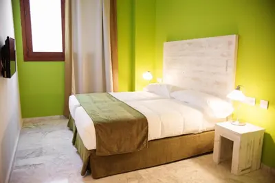 a bedroom with a large bed with green walls at Ad Hoc Carmen in Valencia
