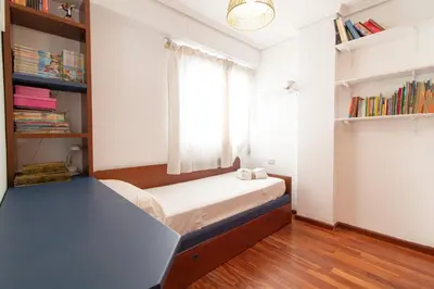 a small bedroom with a bed and a window at Global Vacacional, Apartamento cerca de la playa en Puerto Sagunto in Puerto de Sagunto